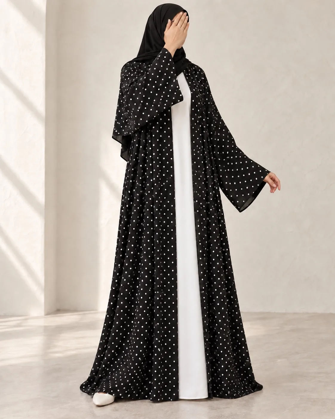 Black Dot Abaya three-quarter view with white dots and wide sleeves